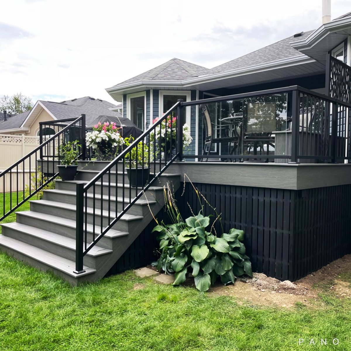 A composite deck with glass panel and black aluminum railing